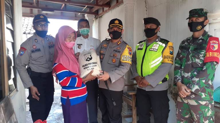 Kapolres Ponorogo AKBP. Muchamad Nur Aziz saat memberikan bantuan beras dan paket sembako kepada warga kurang mampu di kelurahanan Banyudono. 