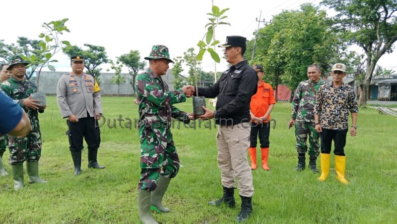 Danramil Sambit Kapen Czi Eko Hadi mewakili  Kodim 0802 Ponorogo  menyerahkan menyerahkan bibit pohon kepada Camat Mlarak  Joko Setiawan .